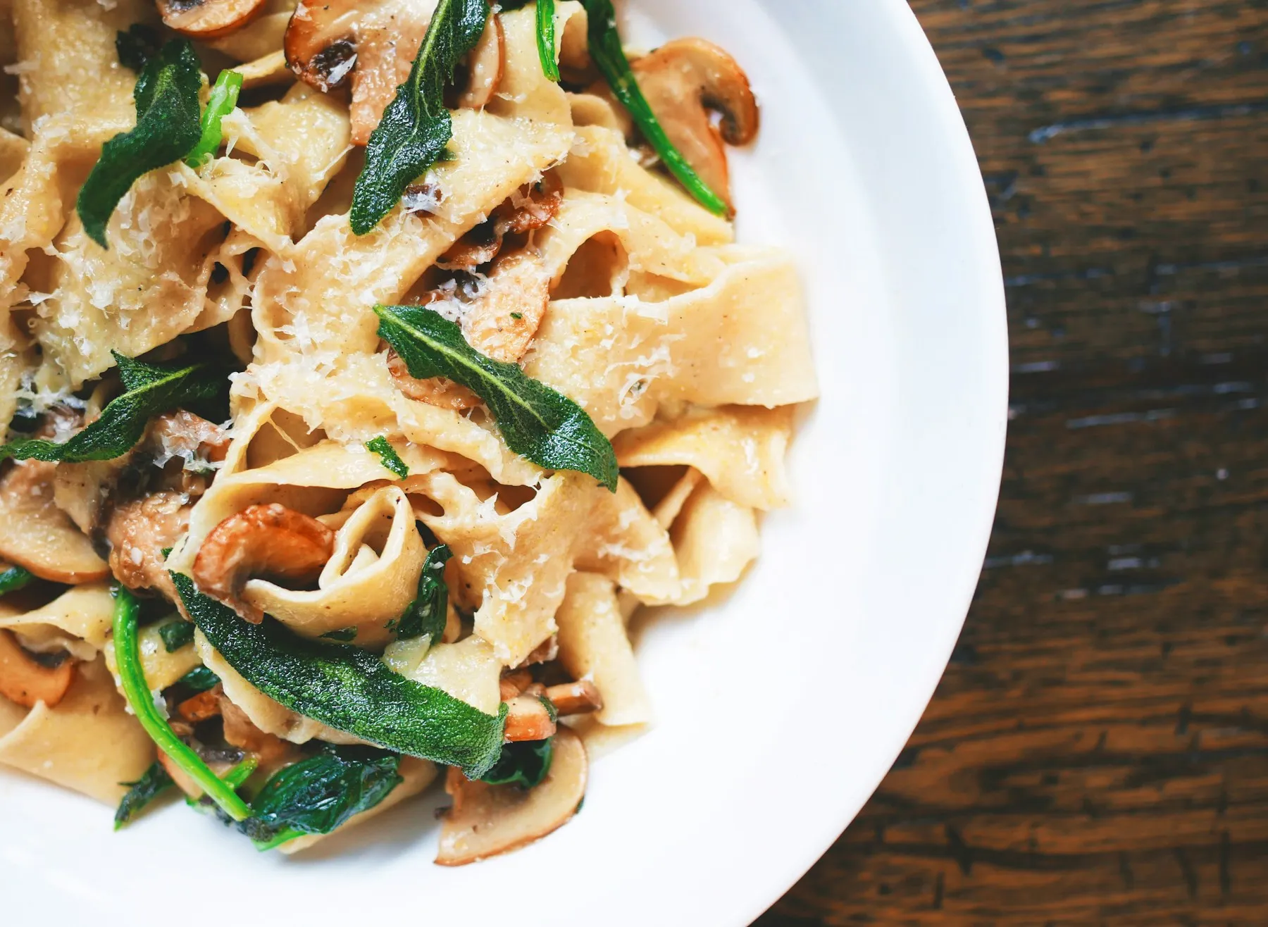 Frische Pasta mit Käse und Kräutern auf einem weißen Teller
